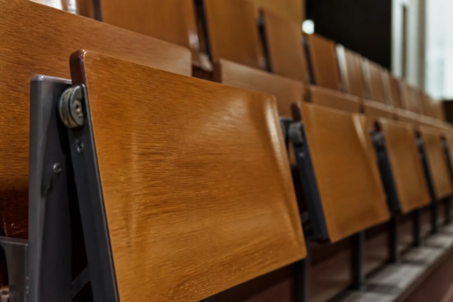 Un amphithéâtre vide avec ses tablettes rabattables en bois