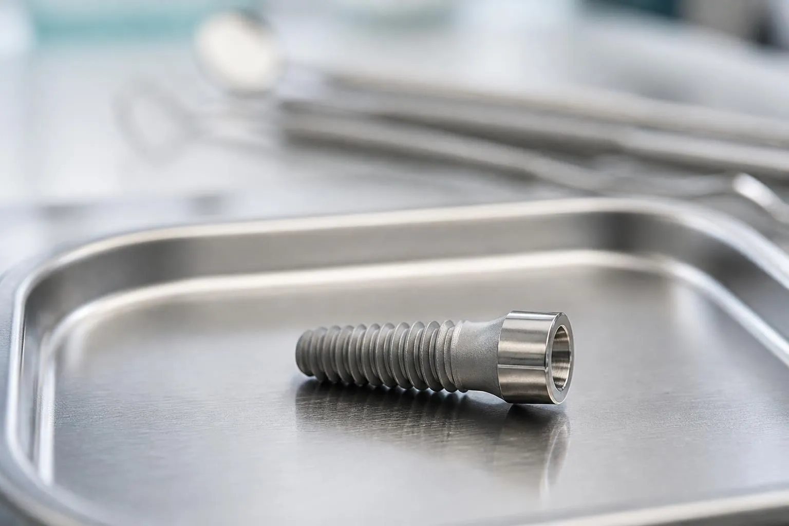 Une vis d’implant en titane sur un plateau en inox